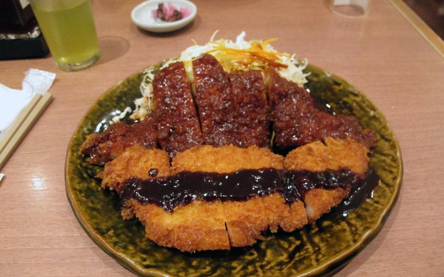 Miso katsu, shown on the upper half of the plate, is a Nagoya specialty. On the opposite site of the plate is a more common version of Japanese deep-fried pork.