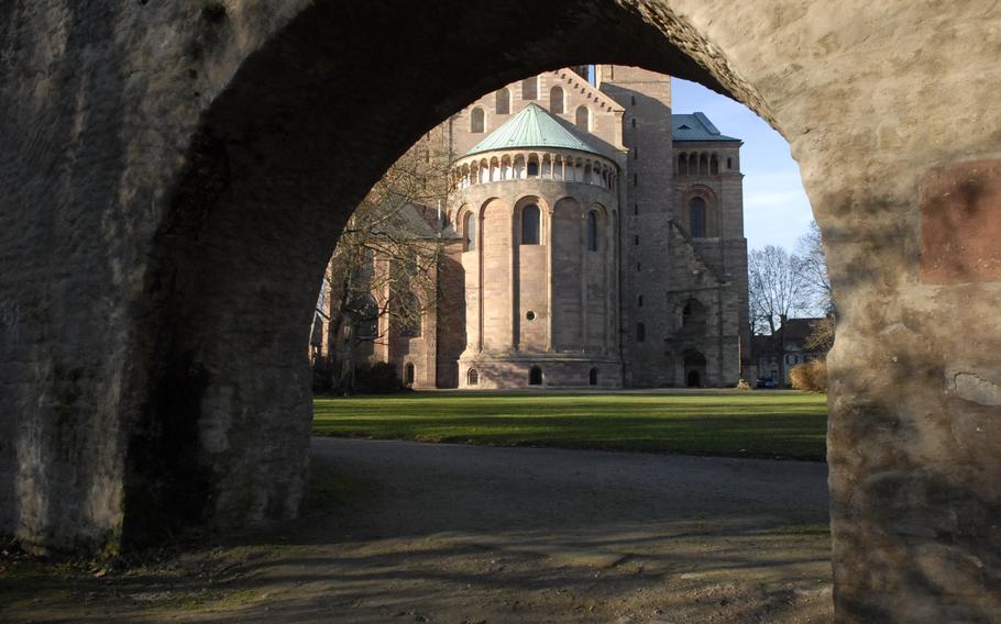 Part of the Speyer cathedral in Speyer, Germany, can be seen through a stone arch from the gardens surrounding the east end of the cathedral. The cathedral is the world's largest-standing Romanesque church. The original construction of the massive stone structure was completed in 1061.