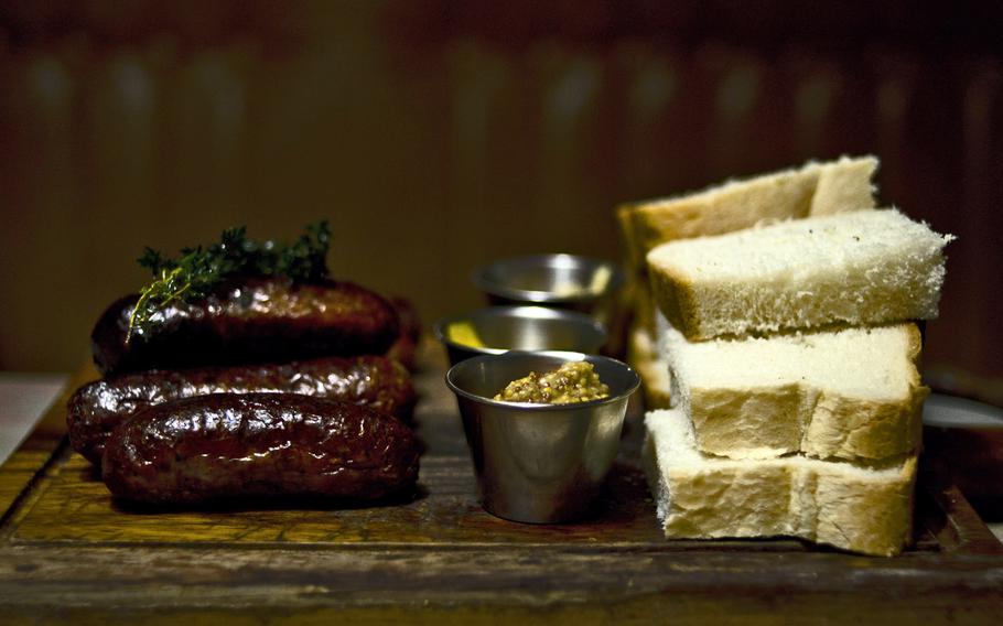 The sausage board at The Cambridge Brew House in Cambridge, England, could be a sharing platter or a meal for a solitary carnivore. It includes various kinds of sausages, three mustards and a pile of white bread, 