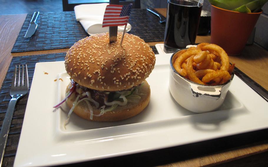 A thick burger topped with an American flag is served with crispy, curly fries at the Tower 66 Steakhouse & Bar in Boeblingen, Germany. The menu is loaded with beef specialties. Prices also are reasonable.