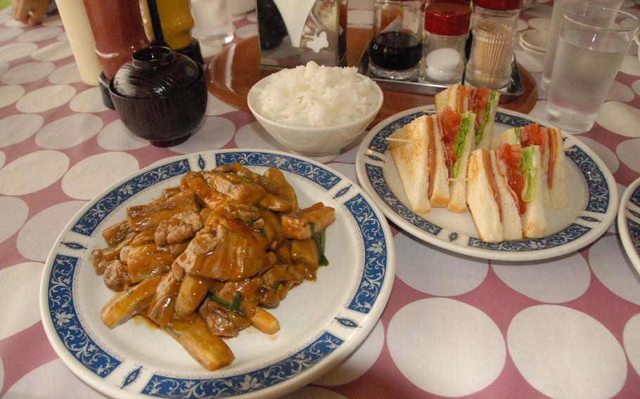 A miso-flavored eggplant and pork dish, left, and the Seaside club sandwich are highlights of the diner menu at the Seaside Drive-In, on Okinawa. The diner is open around the clock.