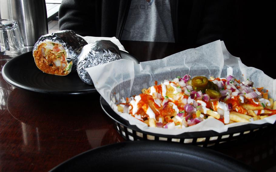 Shown, left to right, are chili lime shrimp burrito and kimchi fries, covered with onions, sour cream, sauteed kimchi and cheese, at Vatos Urban Tacos in Itaewon. The fries are normally also topped with braised pork.