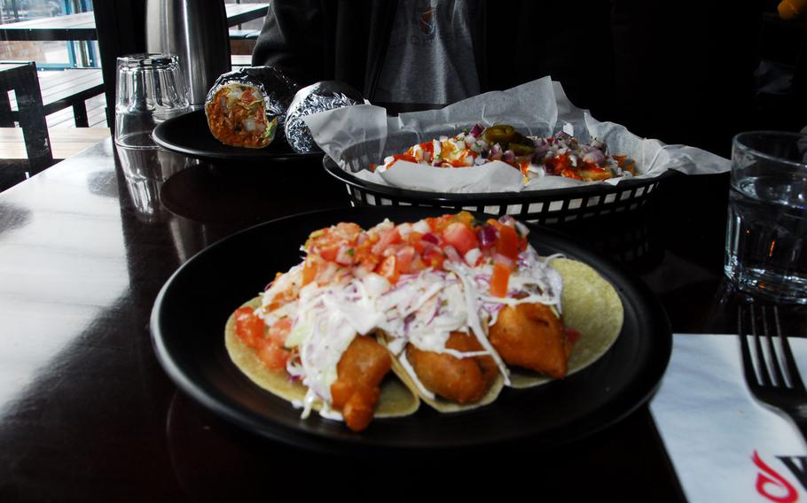 Shown, front to back, are baja fish tacos, kimchi fries, and a chili lime shrimp burrito at Vatos Urban Tacos in Itaewon, near U.S. Army Garrison Yongsan.
