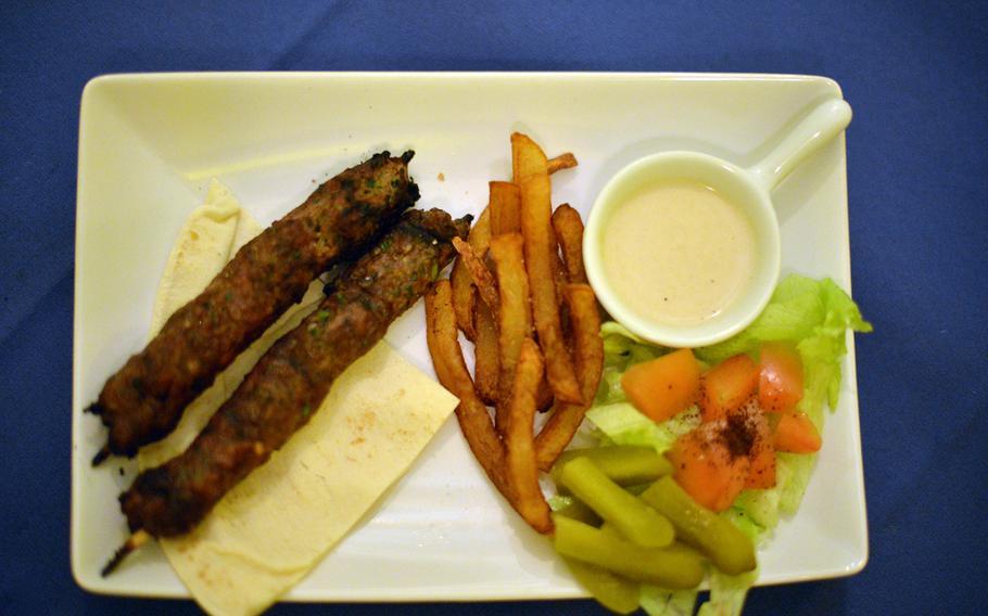 The "kafta" at Ristorante Beirut in Pozzuoli, Italy, is a skewered meatball served with tahini, fries, pickles and a piece of pocket bread. The dish goes well with a hot sauce available from the kitchen.