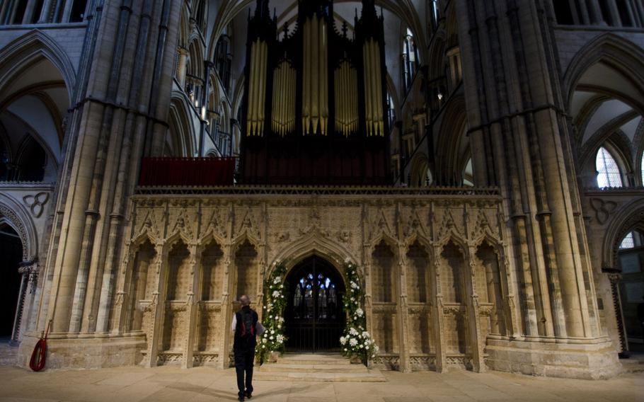 A visitor to Lincoln Cathedral walks in front of the choir screen, a partition that separates the main seating area of the church from the choir and high altar.
