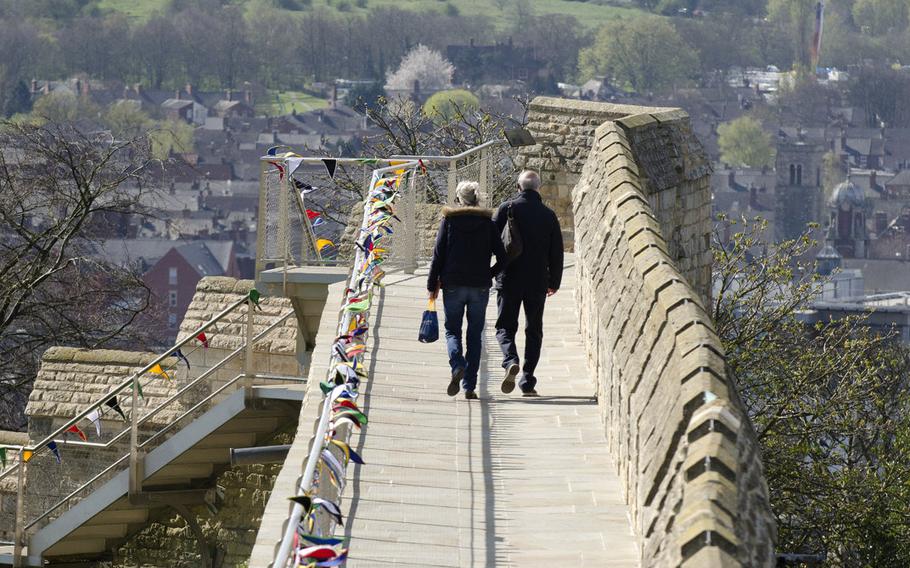 Visitors walk the walls of Lincoln Castle. The castle dates from the time of the Norman invasion of England and was the scene of various conflicts. It was last besieged during the English Civil War in 1644.