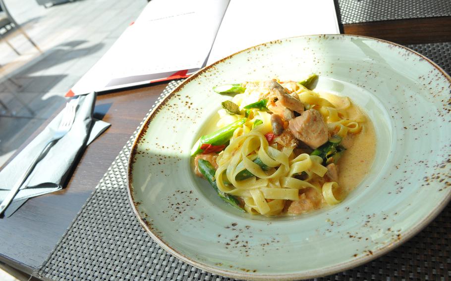 Sunlight hits a corner of a dish of salmon and asparagus served over egg noodles in a cream sauce on a recent afternoon at the Soul Kitchen restaurant inside the SAKS hotel in downtown Kaiserslautern, Germany.  The restaurant serves a mix of different types of foods, with an emphasis on Italian.