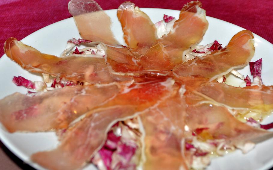 An appetizer at Al Bronzetto in Aviano, Italy, features ham sliced so thin you can see through it on top of seasonal greens.