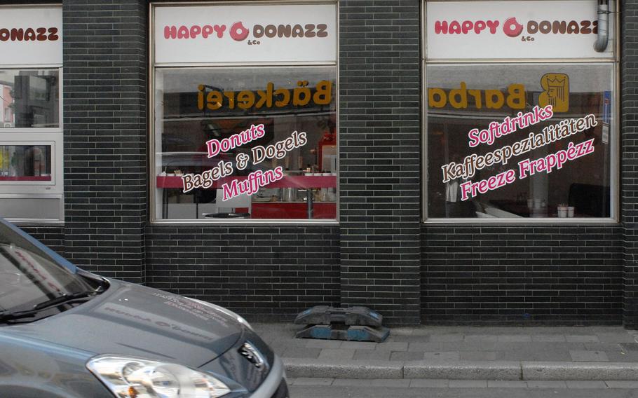 The sign for neighboring eatery Barbarossa Baeckerei is reflected in the windows of Happy Donazz, a newly opened breakfast spot in Kaiserslautern, Germany. The proximity of the two competitors might create a rivalry for sugary breakfast foods in the area.