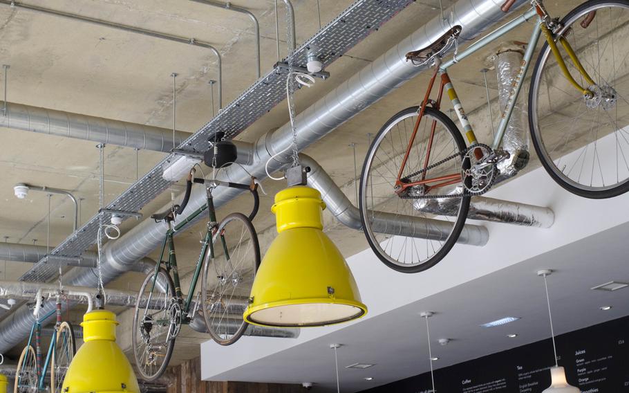 Bicycles hang from the ceiling at Espresso Library in Cambridge, England. These are only decorative. Space for cyclists to store their bikes is found elsewhere.
