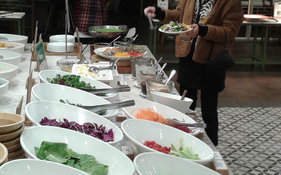 A customer chooses items from the Sevens Springs salad bar in the popular COEX Mall in Seoul, South Korea. 