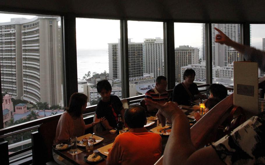 As the sun sets over the beach, diners chat at Top of Waikiki, a restaurant in Honolulu that revolves 360 degrees roughly each hour.