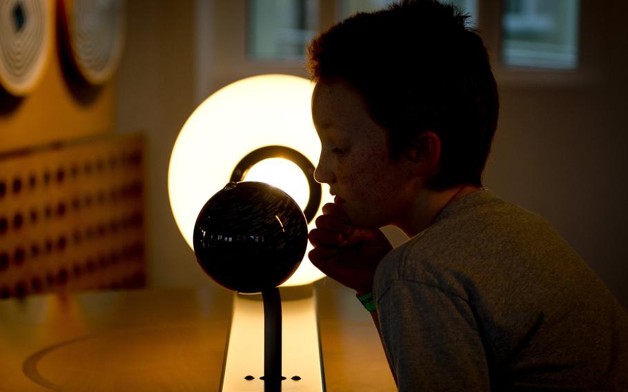 Cuinn Keller, the reporter's son, looks at a globe at the Dynamikum museum that illustrates how the Earth's rotation affects weather.