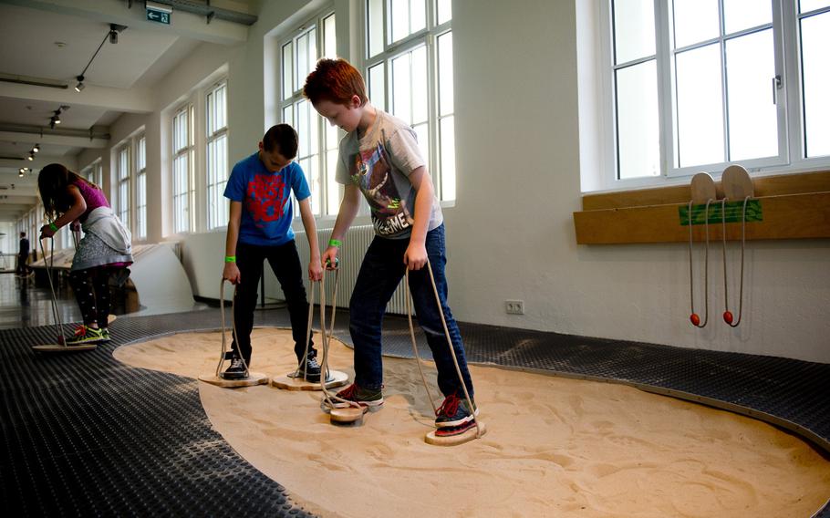 Cuinn Keller, right, and his brother, Conall, make different-shaped footprints in the sand at Dynamikum in Pirmasens, Germany.