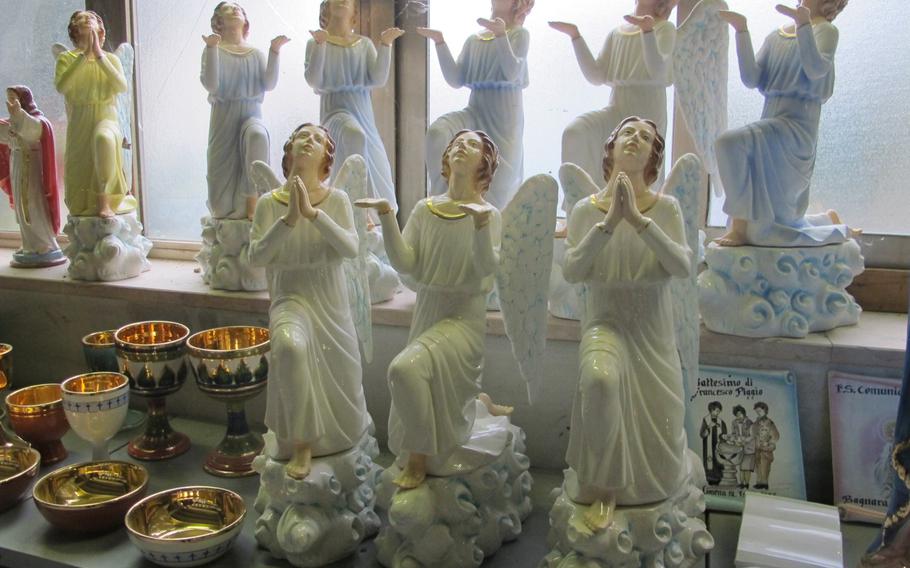Praying angels shine in the window of Ceramiche Larry SKG in Nove, Italy, a small town about 40 minutes northeast of Vicenza, known for its ceramics factories.