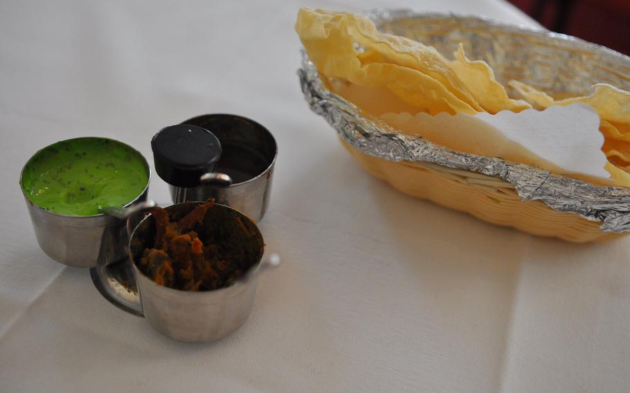 Complimentary "papad," a crispy flat bread, came with a main course of curry at the Curry House restaurant in Kaiserslautern, Germany. The bread was served with three sauces: a creamy mint, a sweet tamarind, and a mixed pickled sauce with garlic, mango and other spices.