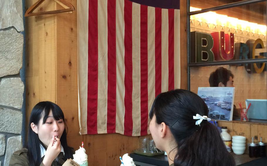 Customers drink melon sodas topped with vanilla ice cream and a cherry at The Great Burger, an American-style burger joint in Harajuku, a Tokyo neighborhood known for its fashion and youth culture.