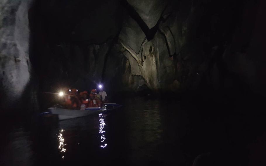 A boatload of visitors float past a butterfly-like cave formation at the underground river in Puerto Princesa, Philippines.