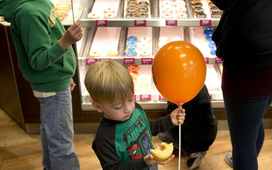 Matthew Stiers eats a doughnut at the grand opening of the Dunkin' Donuts store in the Kaiserslautern Military Community Center at Ramstein Air Base, Germany, on Thursday, June 16, 2016.