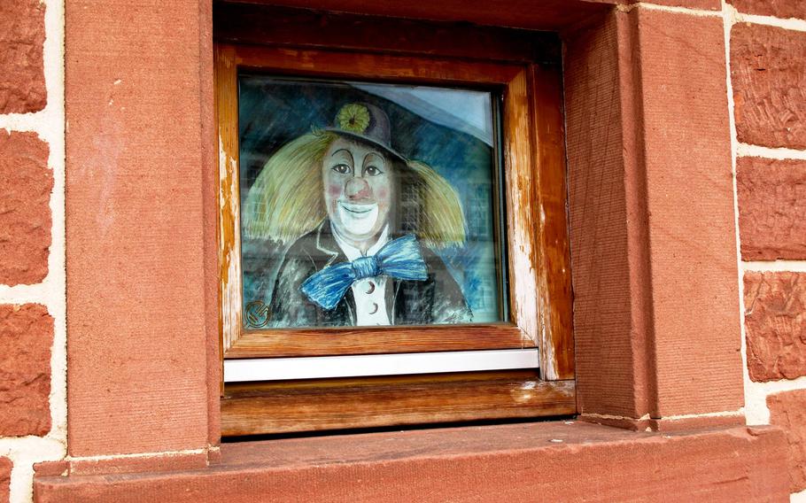 A picture of a smiling clown peers out from a window at Bajasseum in Enkenbach-Alsenborn, Germany. The small museum holds artifacts related to the area's historical circus performers.