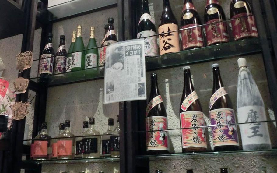 A selection of Japanese sake, including locally brewed Denshu on the top shelf, welcomes customers as they walk into Hohryoh near Misawa Air Base, Japan.