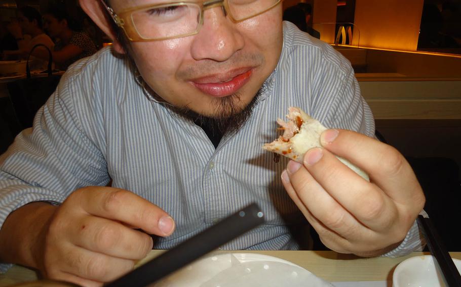 Youichi Suenaga, co-owner of Hong Kong's Ufufu Cafe, shows the proper way to eat Kings' Lodge's signature Peking roast duck.