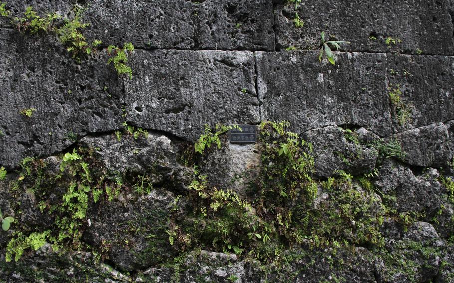 A small sign with arrows points down to indicate Shurijo Castle's original foundation as opposed to that which has been rebuilt.