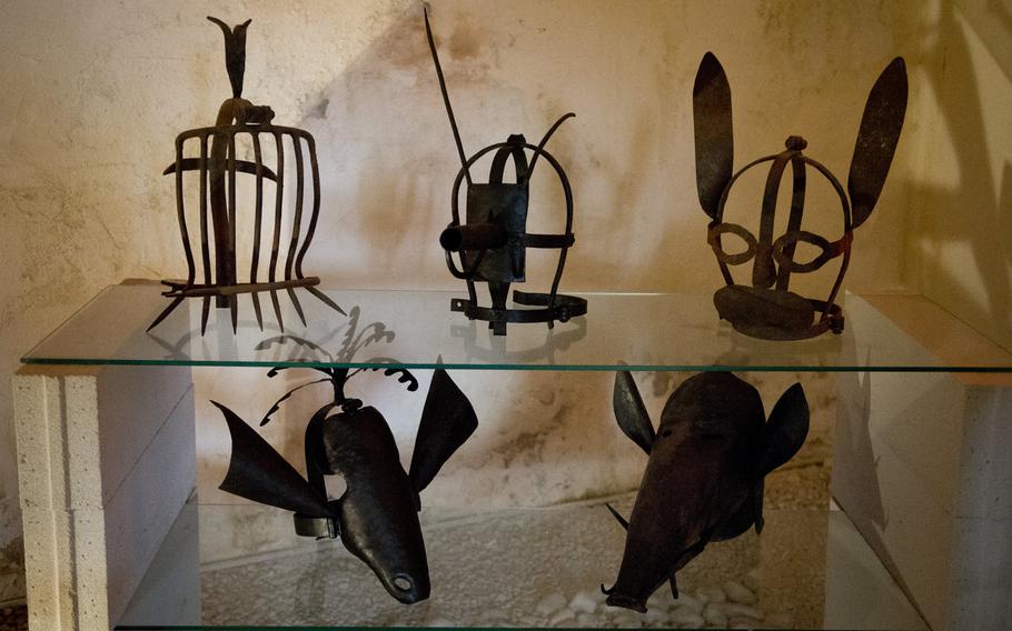 Humiliation masks are on display at the front entrance of the Medieval Torture Museum. The museum's haunting music and garish lighting create an eerie atmosphere that encourages scary thoughts.