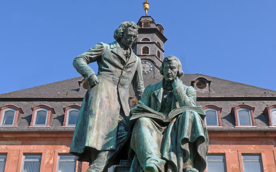 The Brothers Grimm National Monument featuring the fairy tale collectors Jacob and Wilhelm Grimm stands on Hanau's Market Square, in front of the New City Hall.