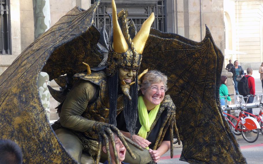 A tourist has her picture taken with one of the human statues on Las Ramblas in Barcelona, Spain. The pedestrian area is known for its street artists. Here the statues seem to move more than they do in other cities.