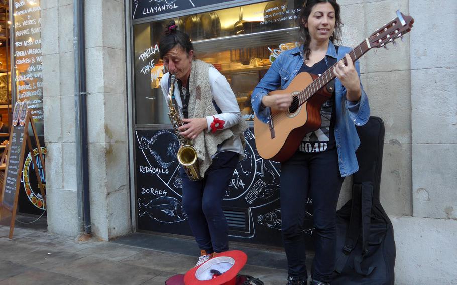 Street musicians entertain diners under the colonnades that surround the lively Boqueria Market, just off of Las Ramblas.