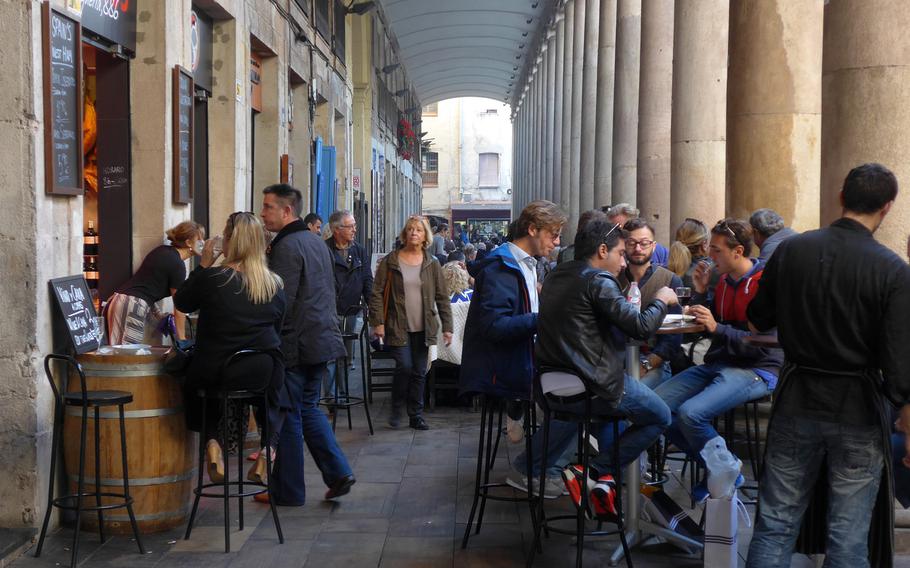 People enjoy food and drink under the colonnades that surround the lively Boqueria Market, just off of Las Ramblas.