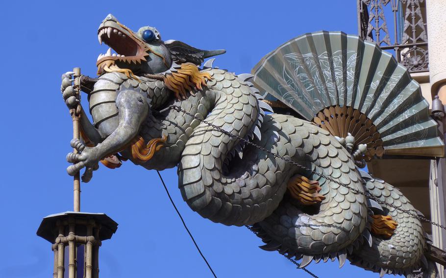 A Chinese dragon adorns a corner of a facade of the Casa Bruno Cuadros on Las Ramblas. The house once was home to an umbrella shop and umbrellas also adorn the facade.