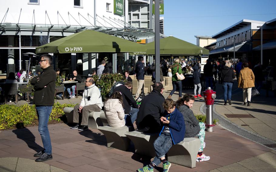 Shoppers take a break in front a restaurant at The Style Outlets in Zweibrucken, Germany, on Monday, Oct. 31, 2016.