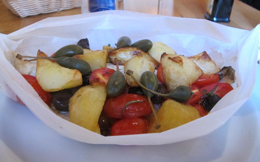 Al Ritrovo's tender seabass fillet is topped with olives, tomatoes, giant capers and crispy potatoes. The restaurant is located across a small piazza from the cathedral in Vicenza, Italy.