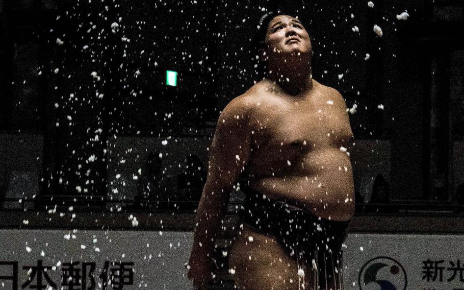 Rikishi sprinkle salt around their bodiesduring a December sumo tournament in Okinawa, Japan.