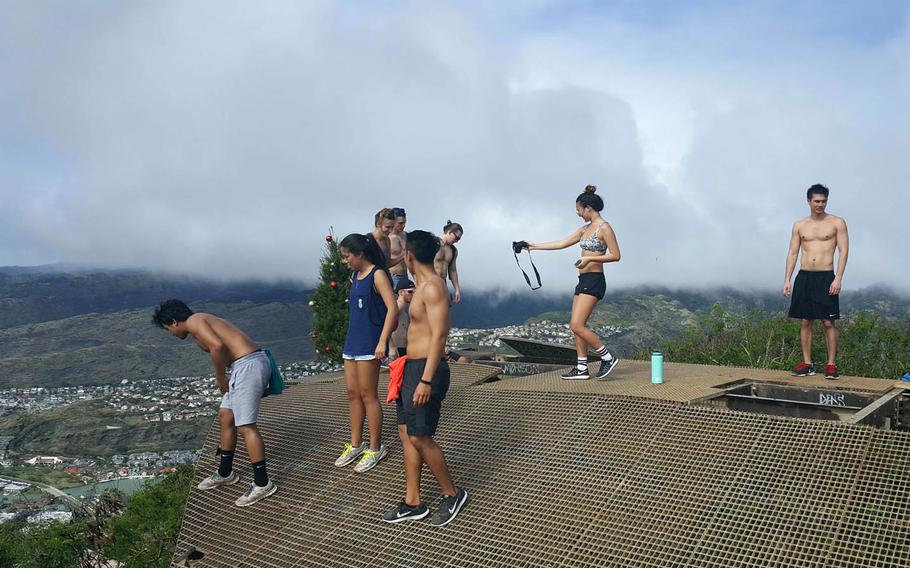 Hikers check out the view from atop the collapsed steel-grated roof that once covered the military tramway terminal on top of Koko Crater in Hawaii.
