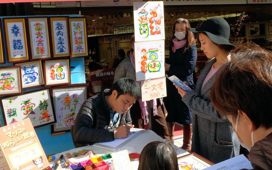 A merchant creates drawings for sale in front of Yokohama Daisekai, an eight-story shopping plaza in the heart of Chinatown in Yokohama, Japan.