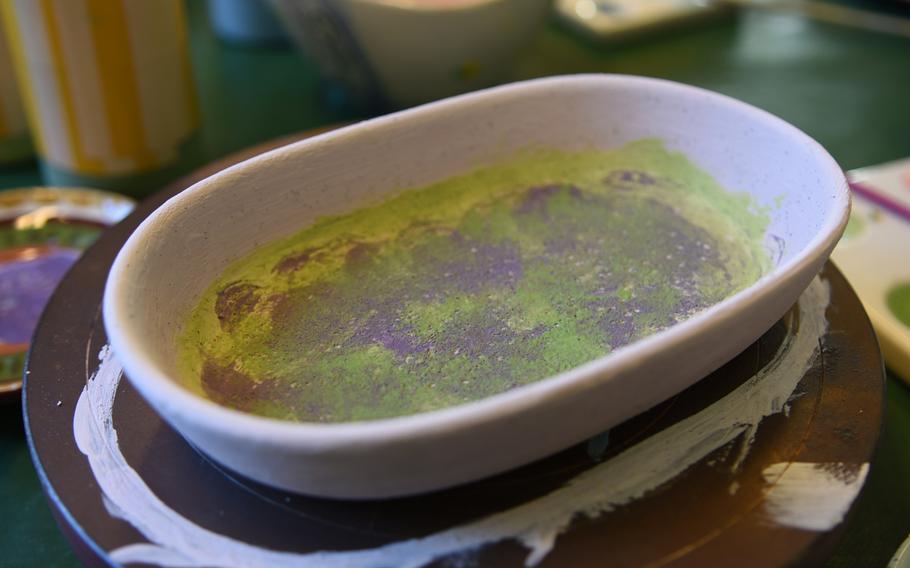 The first attempt at painting a small dish at Mal-Werk in Mainz, Germany, didn't turn out very well. The purple and green were undetectable after they werecovered by several coats of gray paint.
