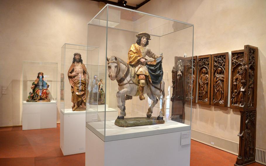 Various statues from the 14th to 16th century are on display at the Unterlinden Museum in Colmar, France. The one in the foreground depicts St. Martin of Tours.