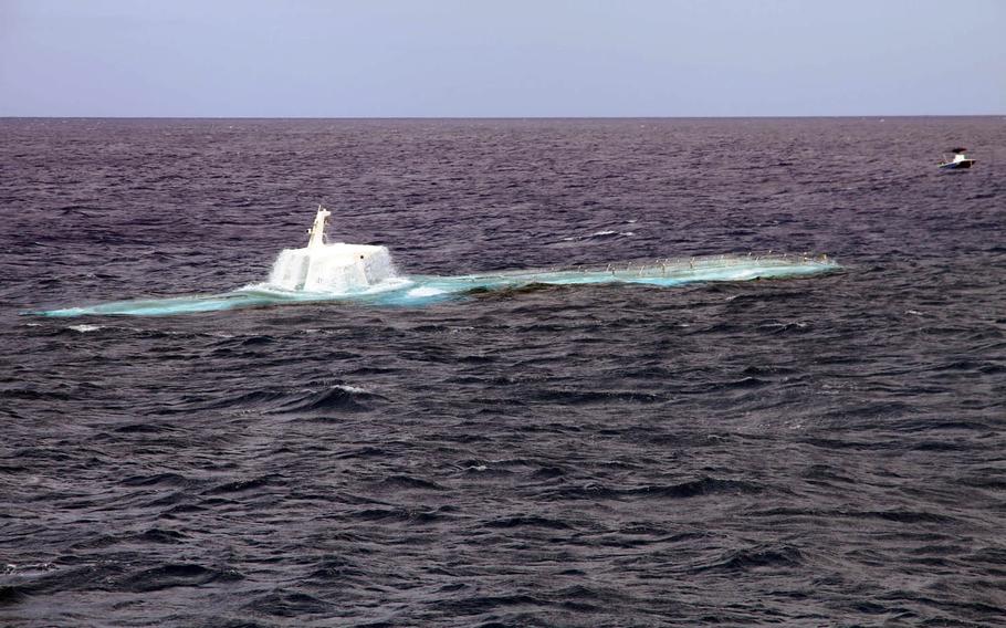 An Atlantis submarine surfaces near the shore of Waikiki Beach, Hawaii, after a recent undersea tour of reefs.