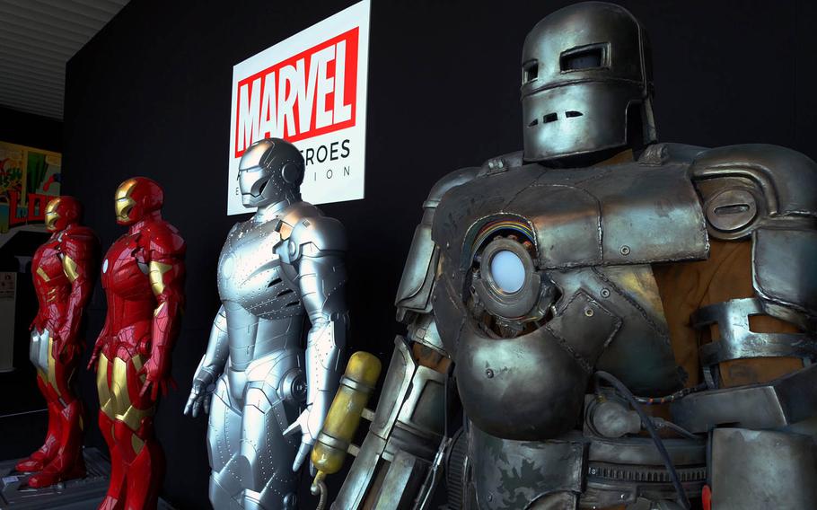 Visitors can pose for a photo with life-size displays of various Iron Man suits from over the past few decades at Marvel's Age of Heroes exhibit in Tokyo.