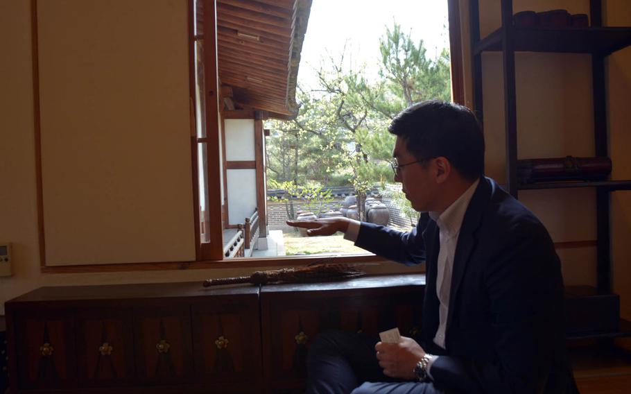Joshua Park, director of strategic planning at the Korea Furniture Museum in Seoul, demonstrates how furniture was built to fit traditional houses at a low level to allow people sitting on the floor to easily look outside and enjoy nature.
