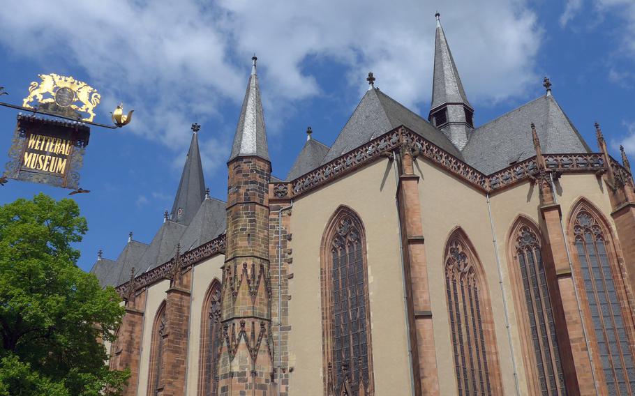 A sign announcing the Wetterau Museum hangs across the street from the Stadtkirche, or City Church, in Friedberg, Germany. The church was built between the late 13th century and the early 15th century.