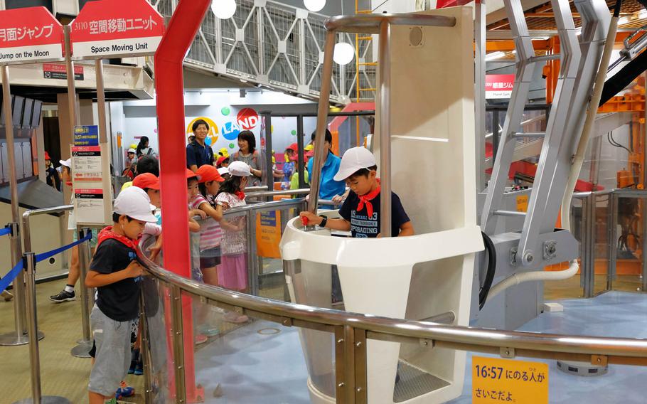 Kids use a space mover to travel without walking at Hamagin Space Science Center in Yokohama, Japan.