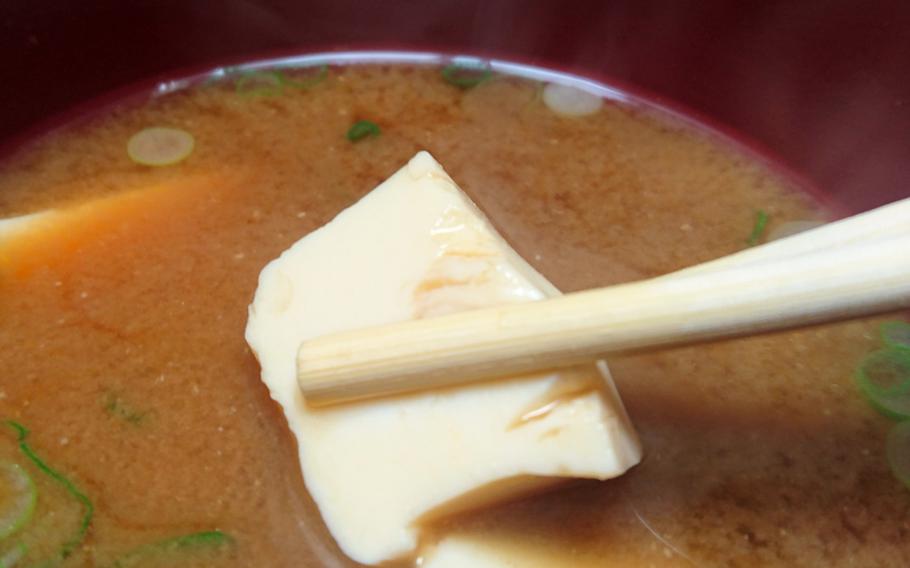 A soft piece of tofu from a slightly steaming bowl of miso soup at the restaurant Abeno in London, England. The soup was included with my okonomi-yaki lunch order.