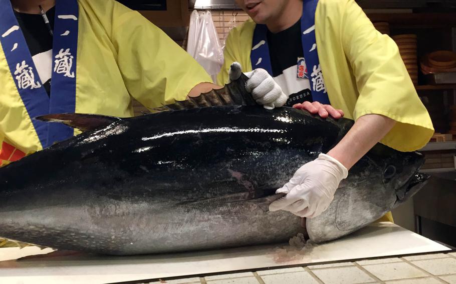 Chefs prepare to carve a tuna at Maguro Shoten.