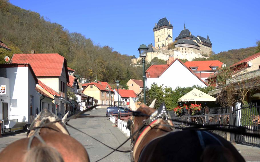 A horse-drawn carriage makes its way up a hill to reach Karlstejn Castle, the seat of Holy Roman Emperor Charles IV, in the Czech Republic.