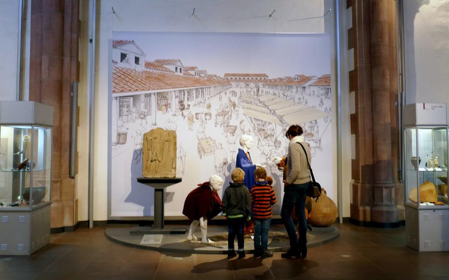 A family visiting the Archaeological Museum in Frankfurt, Germany, looks at a display on Roman life.
