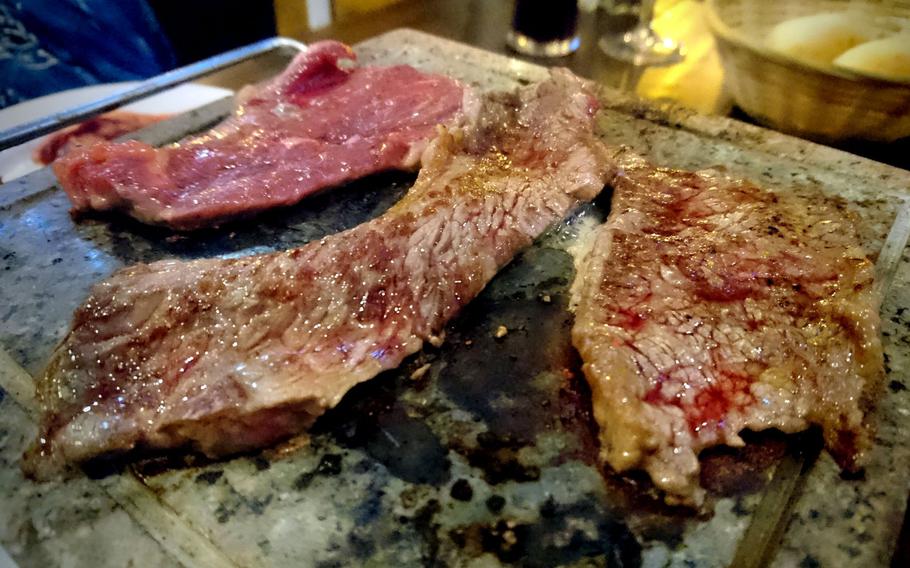 Rump steak seasoned with salt and olive oil sizzling on a hot stone at the Cheers Steakhouse in Bury St. Edmunds, England, Tuesday, November 28, 2017.  Restaurant customers self-cook the traditional Brazilian dish at their table.